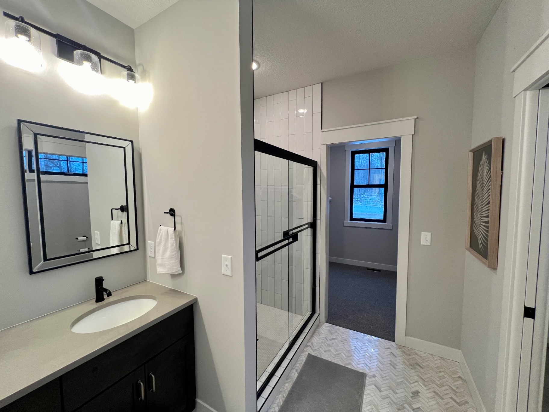 Glass shower and vanity view from the entry.