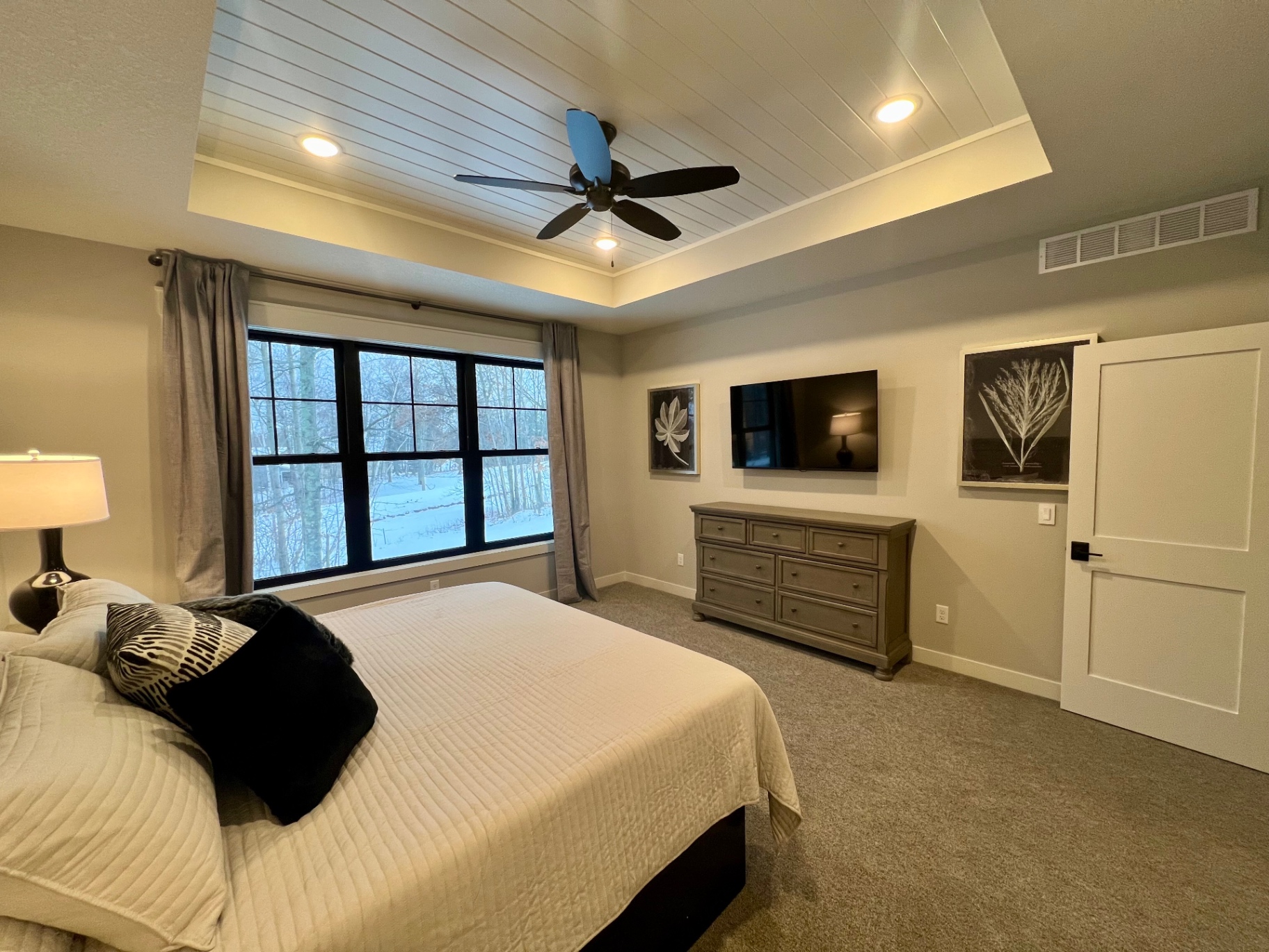 Sitting wall with mounted TV and dresser.