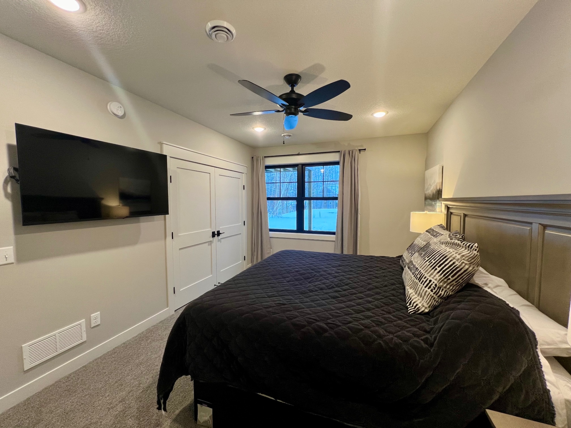 Bed with closet and mounted TV.