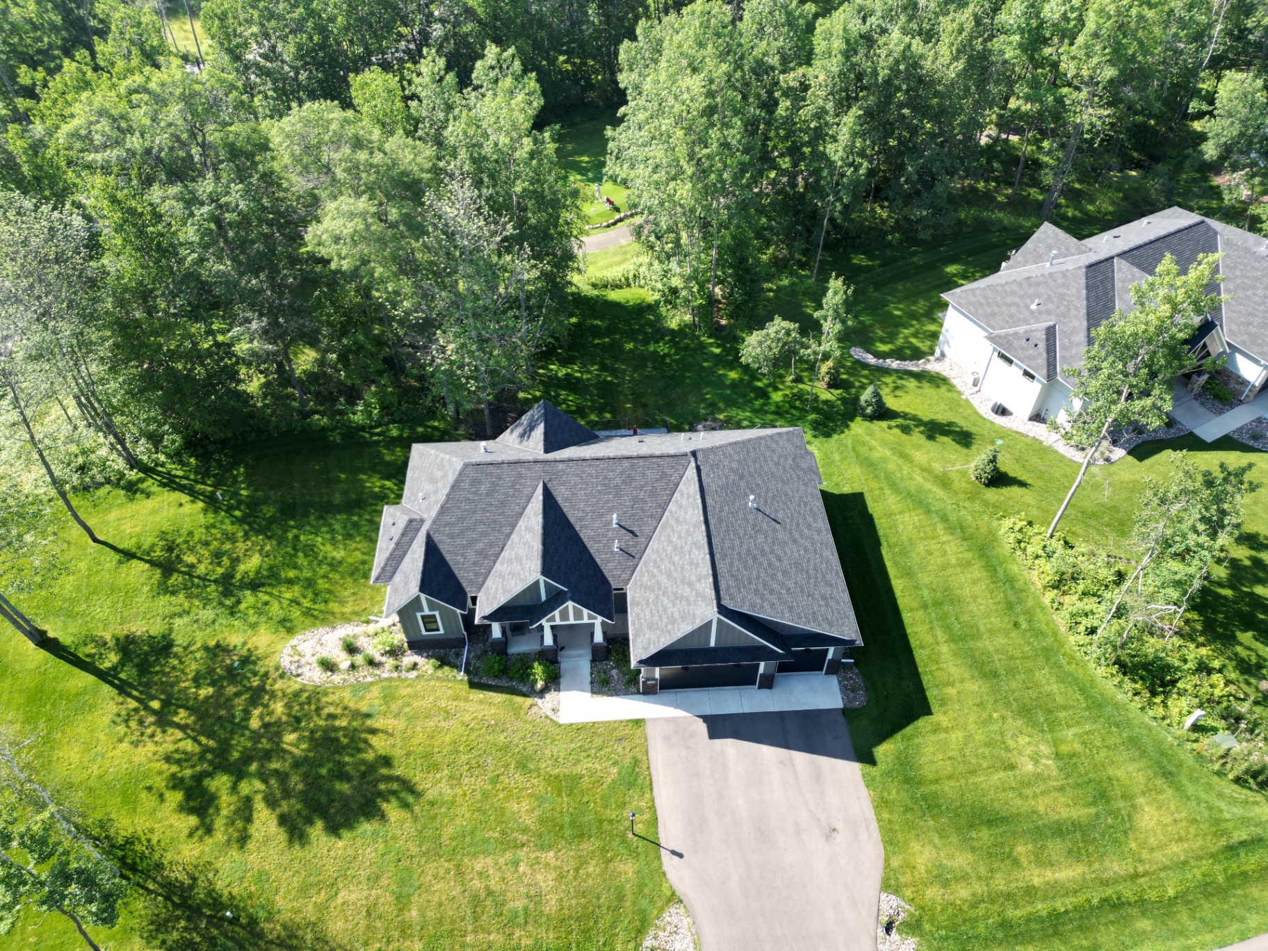 Bird's-eye view of the multi-gable roof tucked into the trees of Nisswa.