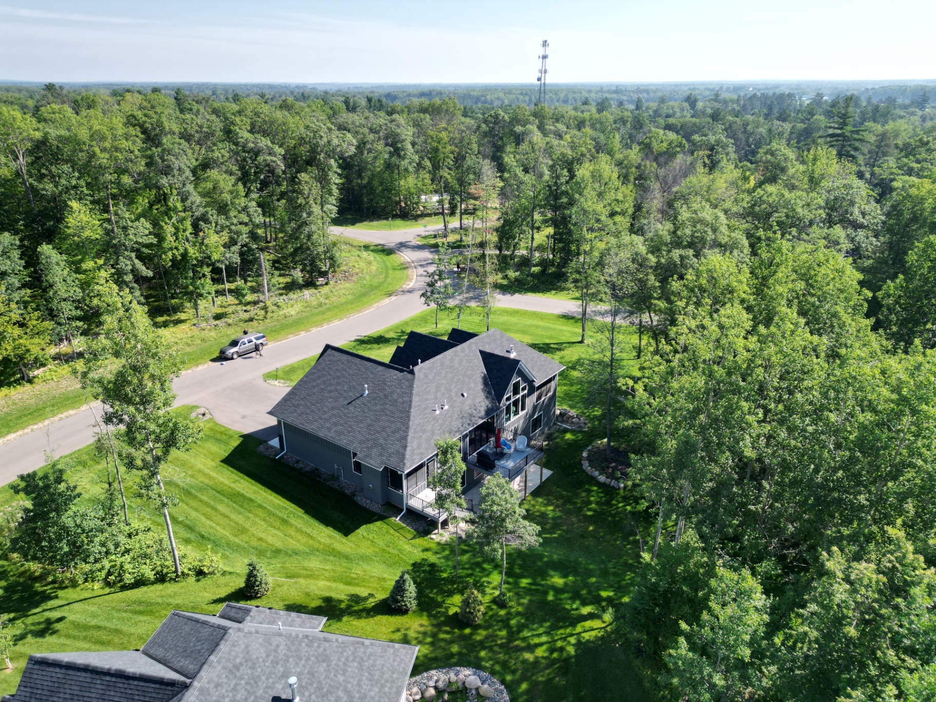Screened porch and open deck overlooking a private lawn and the northern Minnesota canopy.