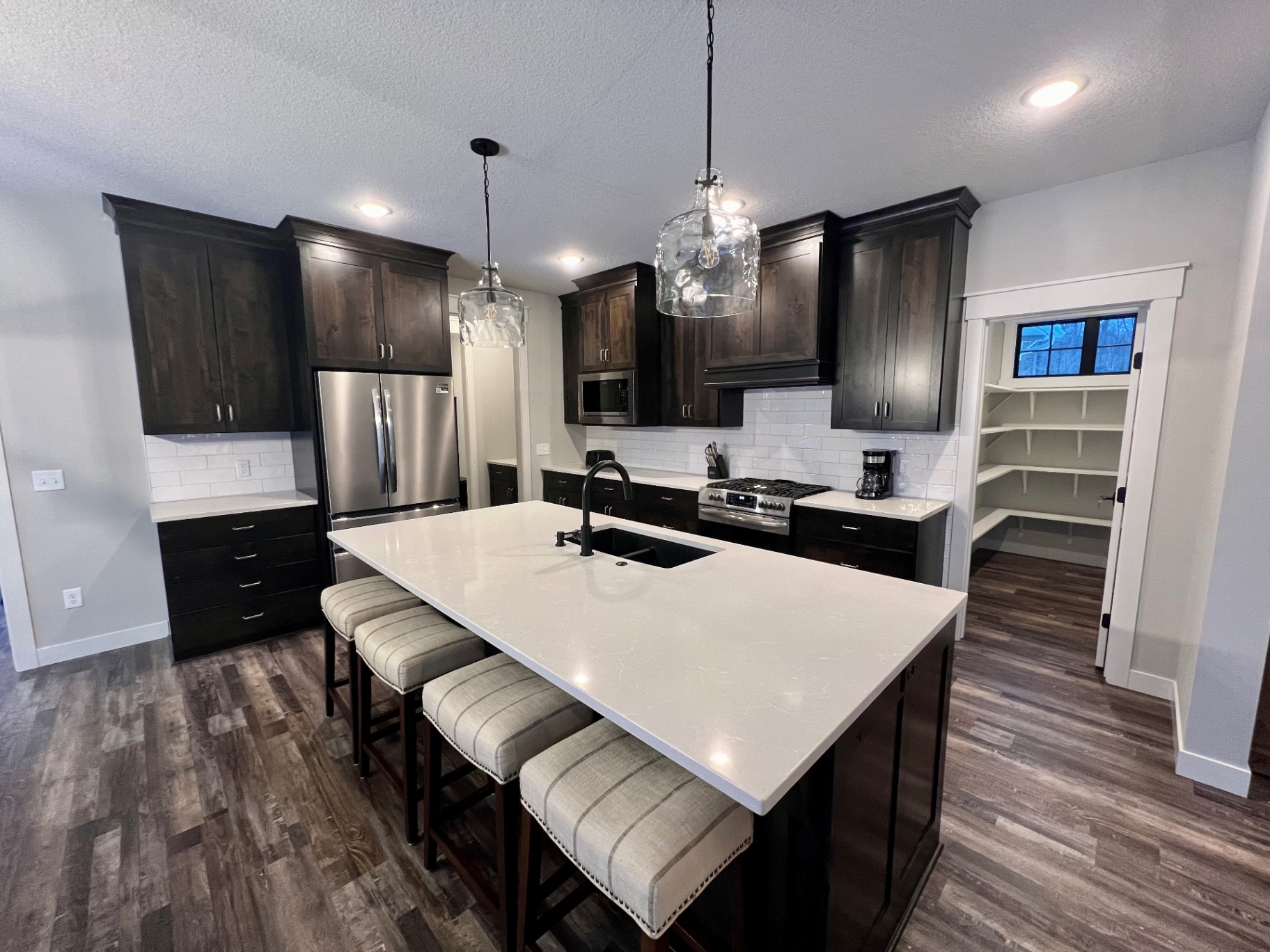 Generous walk-in pantry with built-in shelving just off the kitchen.