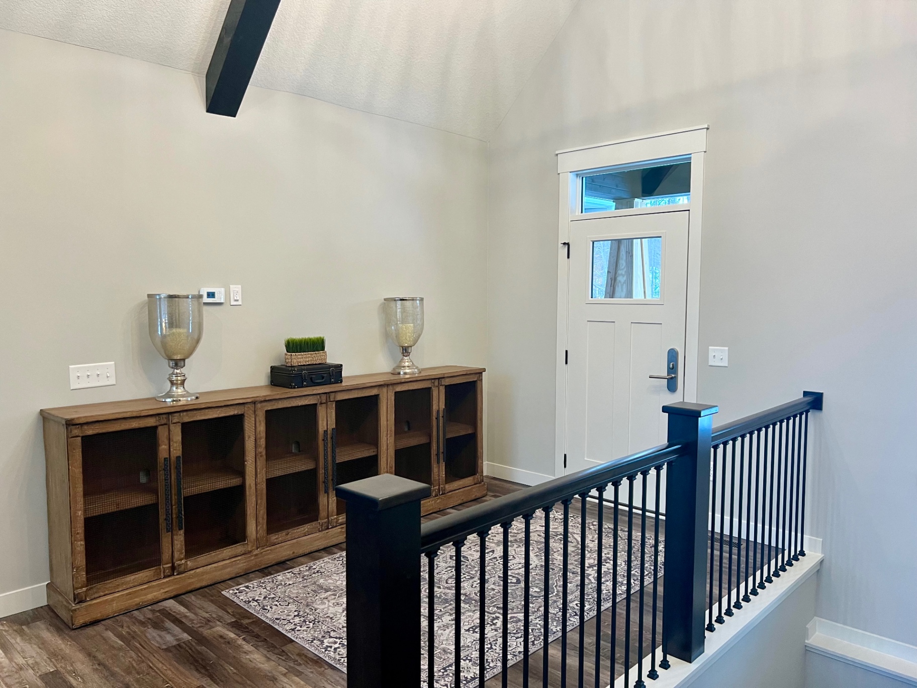 Long sideboard under the vault, framing the front door.